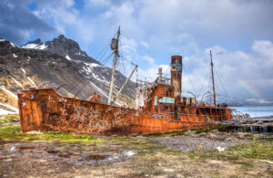 Rusted whaling ship, Grytviken, South Georgia Island with a rainbow in the background