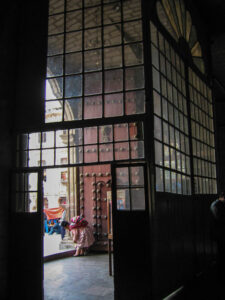 View from the Cathedral, La Paz, Bolivia where a woman in traditional dress is visible from the door